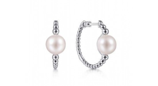 A pair of Gabriel & Co. white gold huggie earrings with pearl accents, available at Drenon Jewelry.