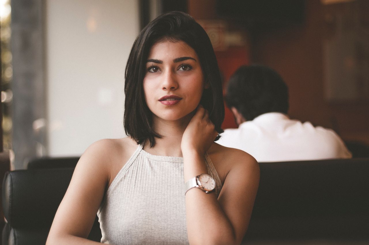 a lady sitting in a restaurant wearing a luxury timepiece