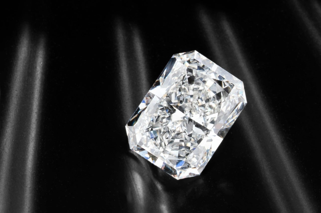 close up image of a radiant cut diamond on a shiny black surface