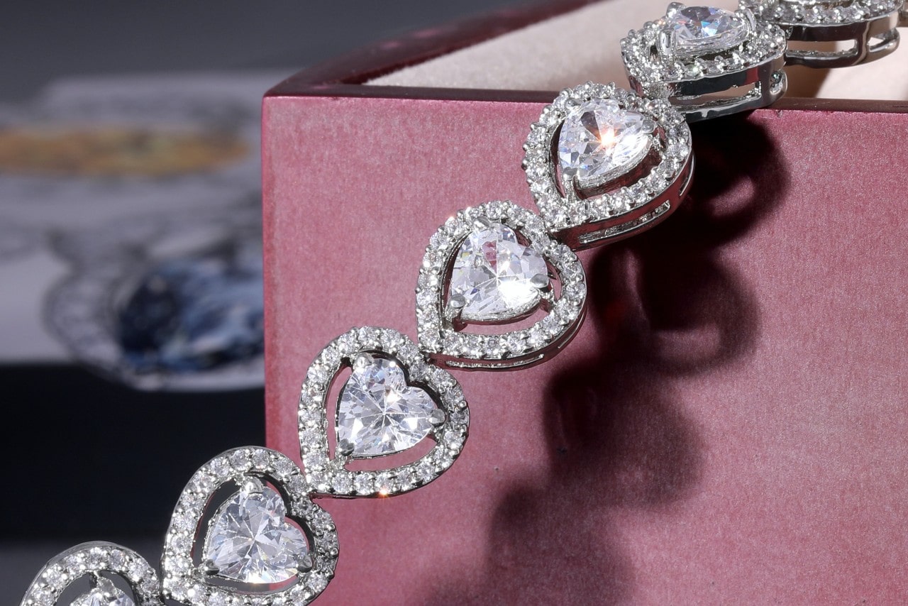 A diamond adorned heart-shaped bracelet on the pink box